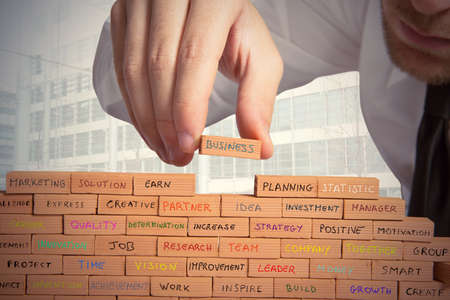 Businessman builds a new business with brickの写真素材