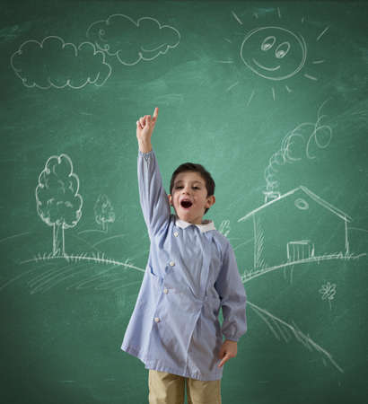 Child in school against a green blackboardの写真素材
