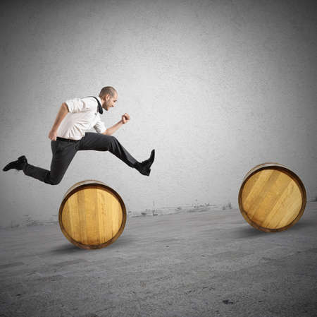 Concept of difficulty with businessman that jumps obstaclesの写真素材