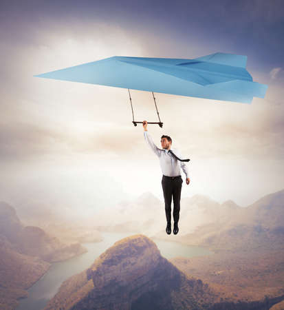 Businessman seeks for new business with a paper airplaneの写真素材