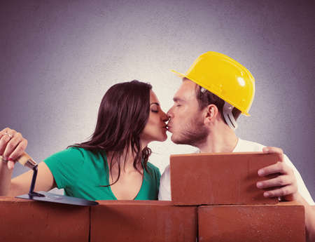 Concept of love with a couple that builds a house with brick