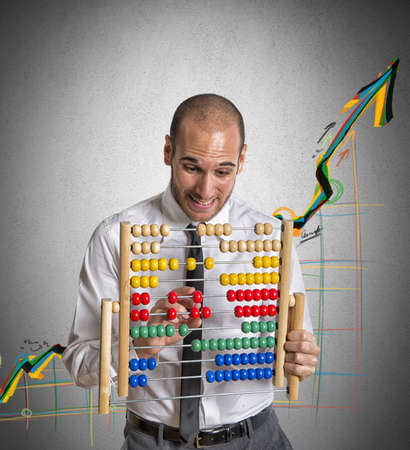 Businessman with abacus calculates a positive trendの写真素材