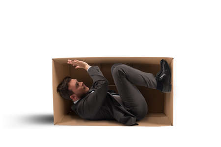 Concept of tight work with a businessman inside a cartonの写真素材