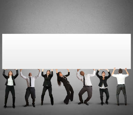 Business team holds a big banner for your messageの写真素材