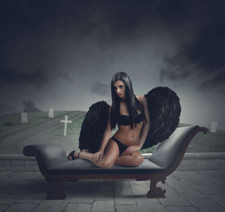 Sexy dark angel in front of a cemeteryの写真素材