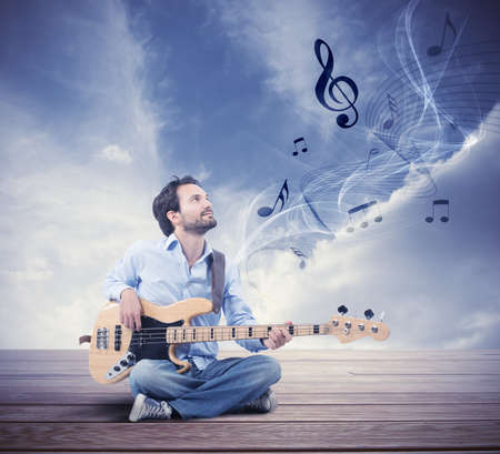 Boy play with electric bass guitar outdoorの写真素材