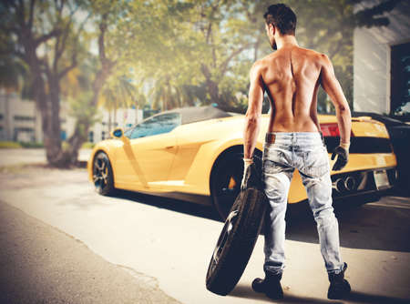 A sexy mechanic repairs a luxury carの写真素材