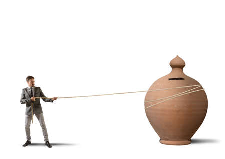 Businessman pulls a moneybox with a ropeの写真素材
