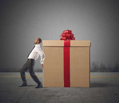 A tired businessman pushes heavy great giftの写真素材