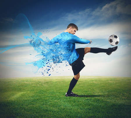 Soccer player kicks ball in a fieldの写真素材