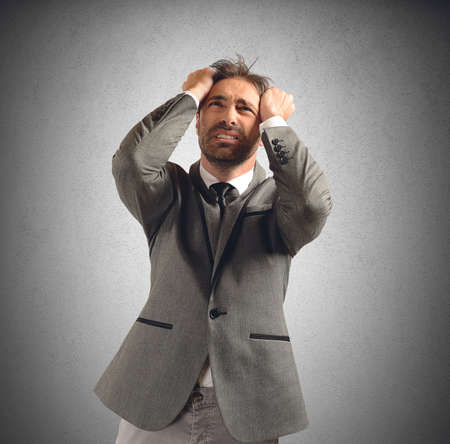 Businessman stressed and desperate for his problemsの写真素材