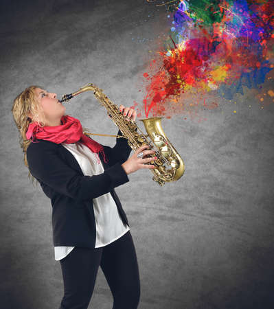 Woman plays beautiful notes from her saxophoneの写真素材