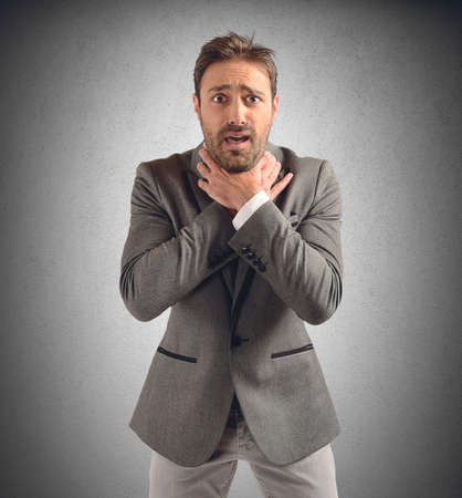 Businessman tries to strangle himself to despairの写真素材