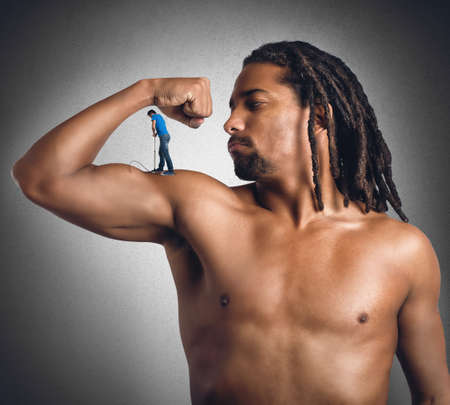 Man inflates his muscles with a pumpの写真素材