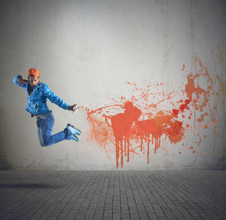 Street boy has fun coloring the cityの写真素材