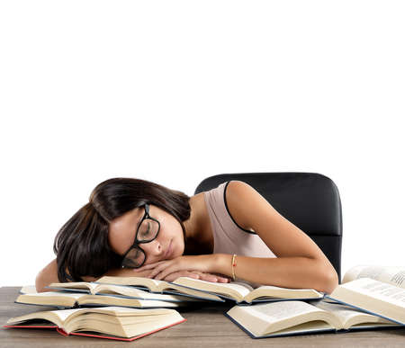 Woman tired of studying sleeping over booksの写真素材