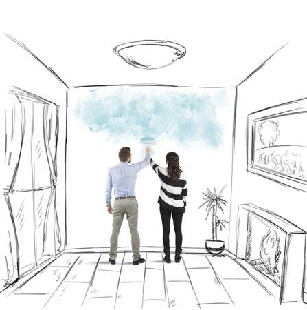 Young couple painting together the walls of houseの写真素材