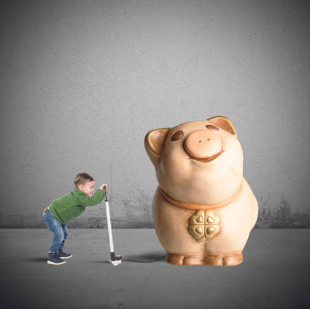 Child tries to inflate his piggy bankの写真素材