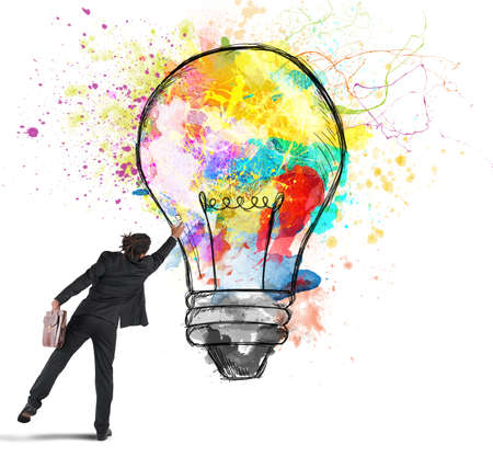 Businessman color with a spray a lightbulbの写真素材