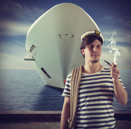 Sailor relaxes and smokes front of shipの写真素材