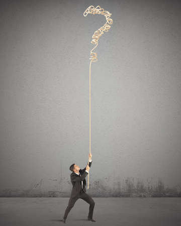 Businessman trying to solve the complicated tangleの写真素材