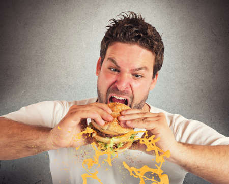 Man eating a sandwich with violent impetuosityの写真素材