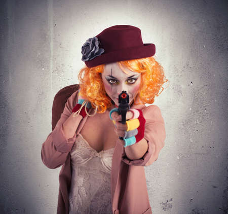 Thief clown aims to hit with gunの写真素材