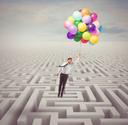 Businessman overcomes obstacles and problems with lightnessの写真素材