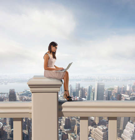 Woman working at pc relax above cityの写真素材
