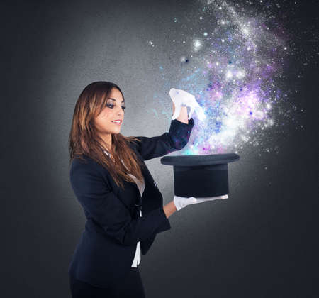 Woman magician makes magic with her hatの写真素材