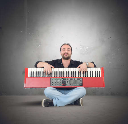 Young pianist plays sitting on the groundの写真素材