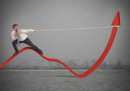 Determinated businessman with much effort lifts statisticsの写真素材