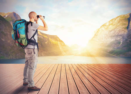Explorer observes a lake in the mountains