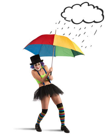 Clowns with rainbow umbrella sheltering from rainの写真素材