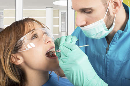 Dentist effects a cleaning of the teethの写真素材