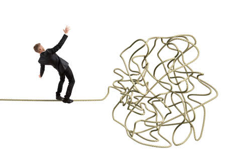 Businessman balancing attempts to get to tangleの写真素材