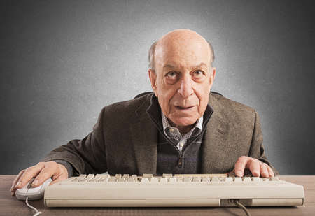 Elderly nerd work with his vintage keyboard