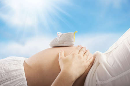 Pregnant woman touching her belly with handsの写真素材