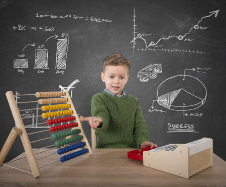 Child plays to make calculations with moneyの写真素材