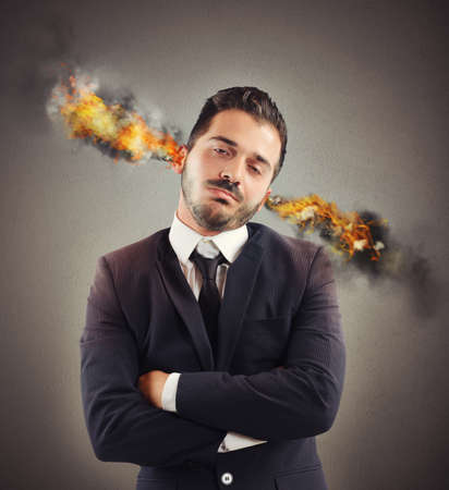 Businessman stressed out with ears in smokeの写真素材