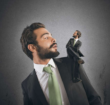 Businessman with small himself in the shoulderの写真素材