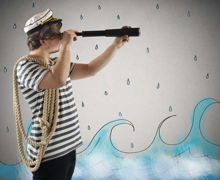 Sailor looks at the sea with the telescopeの写真素材