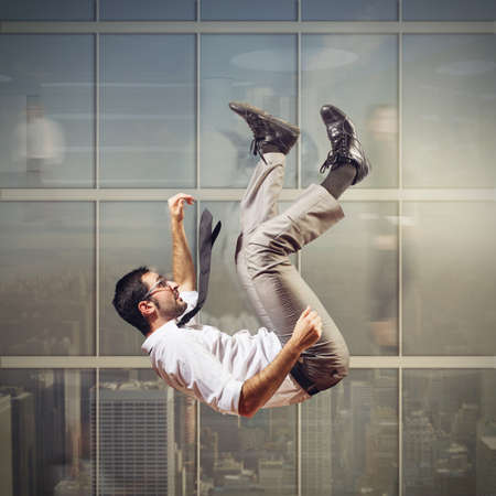 Businessman rushes down from a tall skyscraperの写真素材