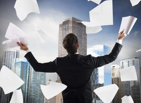 Successful man exults and throws work documentsの写真素材