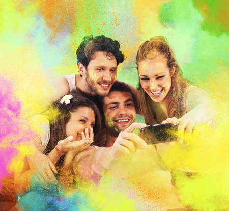 Smiling friends taking a colorful party photoの写真素材