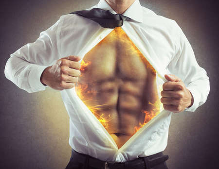 Businessman opens shirt with abs of fireの写真素材
