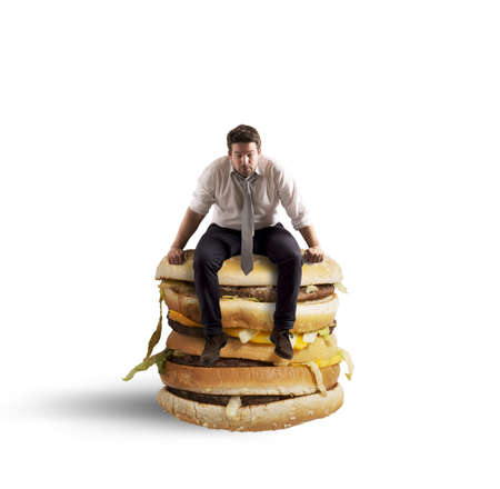 Businessman tired and hungry sitting on sandwichの写真素材
