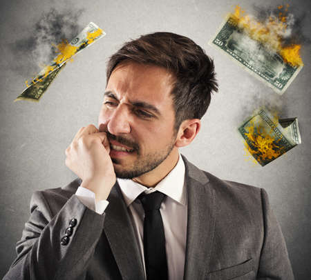 Angry businessman with money which are flammableの写真素材