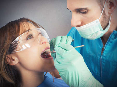 Dentist effects a cleaning of the teethの写真素材