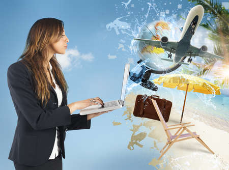 Businesswoman plans with computer her summer vacationの写真素材